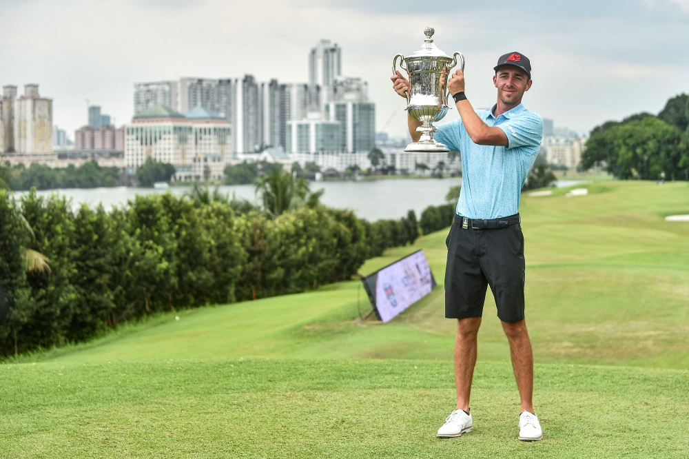 Spain's David Puig poses with the trophy after winning the final round of the Malaysian Open at the Mines Resort and Golf Club in Seri Kembangan on February 18, 2024. (Photo by Arif Kartono / AFP)