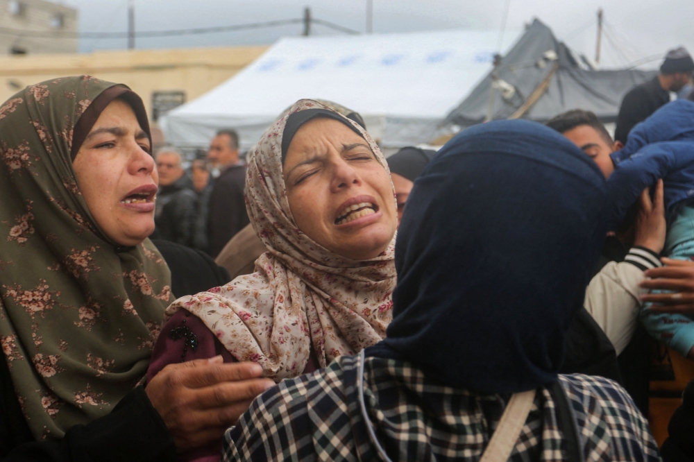 Women mourn after the death of relatives in an Israeli air strike that hit the Baraka family home in Deir al-Balah in the central Gaza Strip on February 18, 2024. (Photo by AFP)