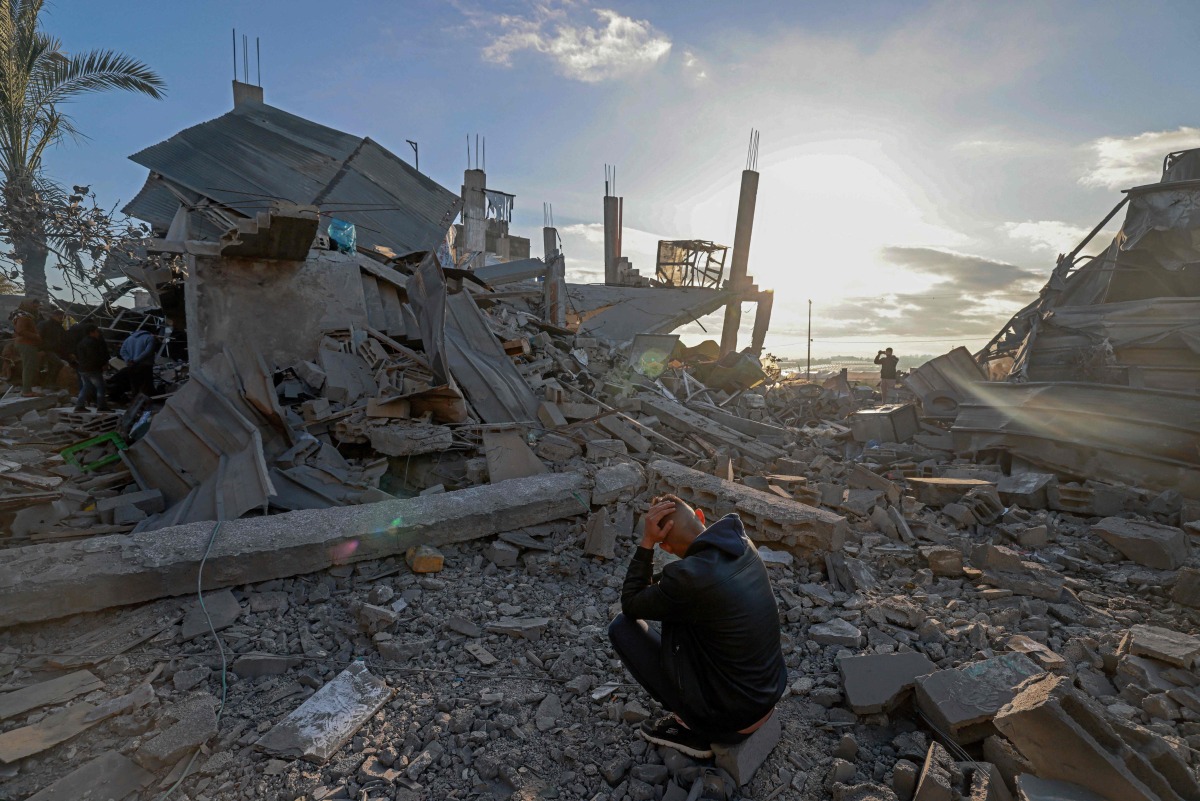  A man sits amid the debris of destroyed houses in the aftermath of Israeli bombardment in Rafah in the southern gaza Strip on February 22, 2024. (Photo by MOHAMMED ABED / AFP)