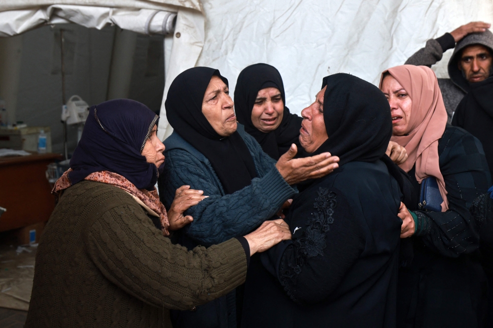 People mourn relatives killed in overnight Israeli bombardment, outside the Al-Najjar hospital in Rafah in the southern Gaza Strip on February 23, 2024. (Photo by Mohammed Abed / AFP)