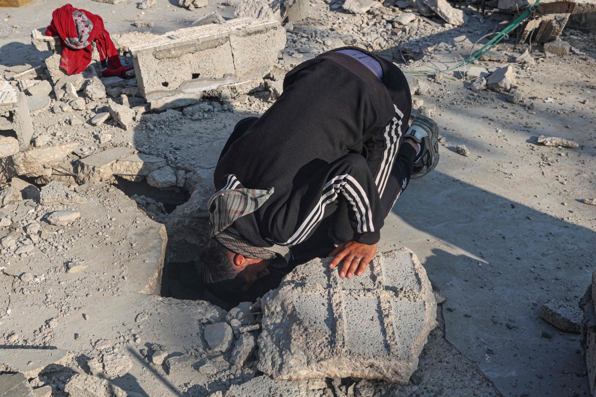 Palestinians search the rubble of their house destroyed in an overnight Israeli air strike in east Khan Yunis in the southern gaza Strip on February 26, 2024 (Photo by SAID KHATIB / AFP)
