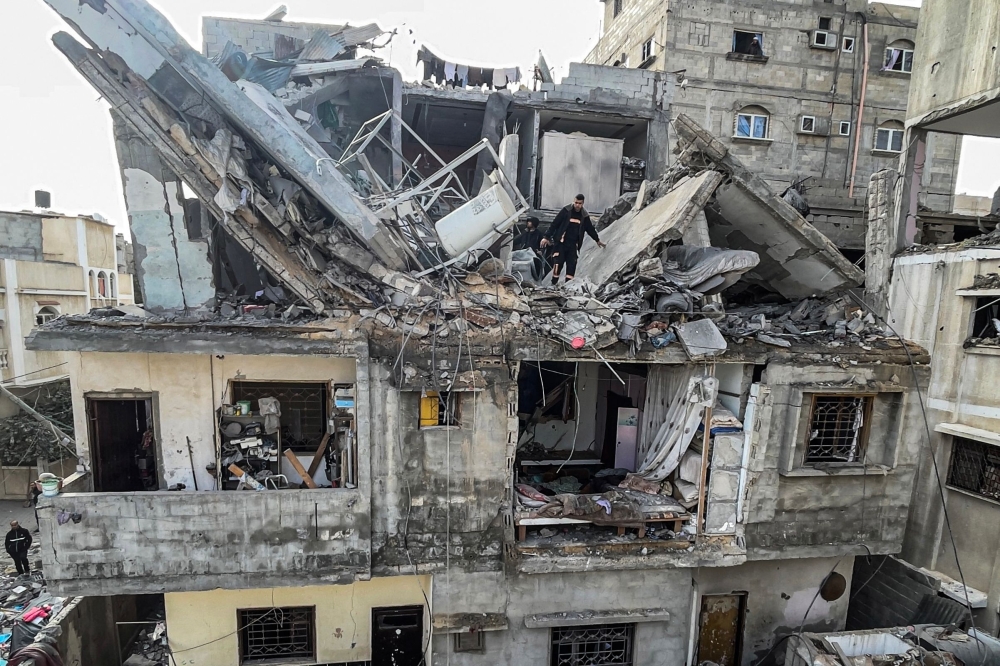 Palestinians search the rubble of their house which was destroyed in an overnight Israeli air strike in the Rafah refugee camp in the southern Gaza Strip on February 27, 2024. (Photo by Said Khatib / AFP)
