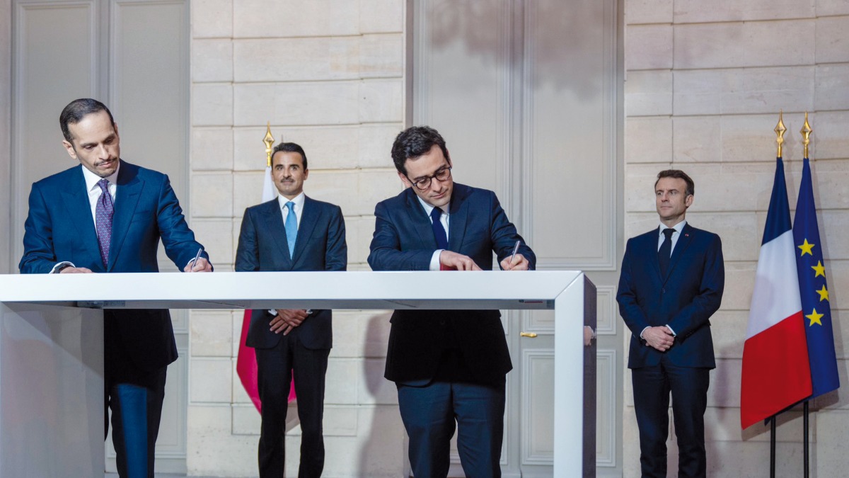 Amir H H Sheikh Tamim bin Hamad Al Thani and French President H E Emmanuel Macron witness signing of an agreement.
