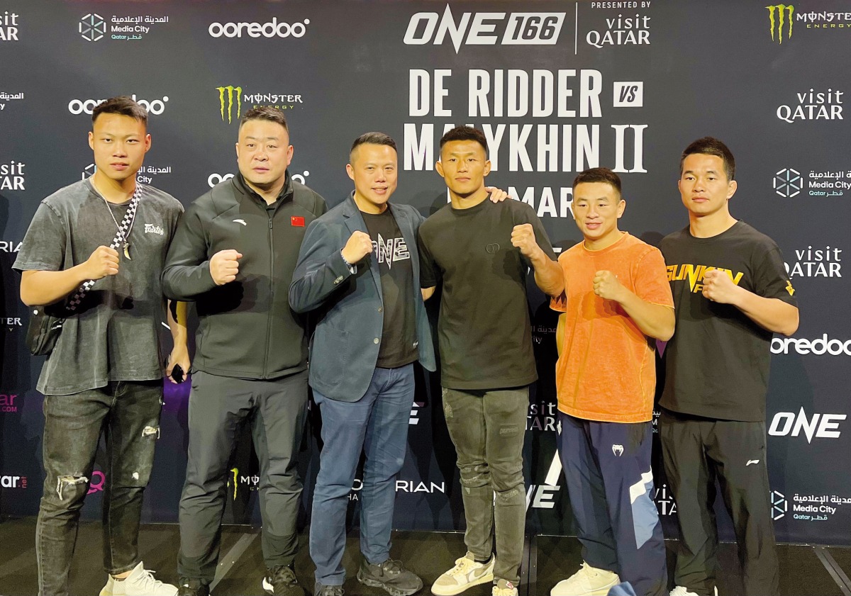 Featherweight MMA World Champion Tang Kai (fourth left) of China poses with the One Championship's Co-Founder and Group President Hua Fung Teh (third left) and his team following a press conference held in Doha, on Tuesday. 