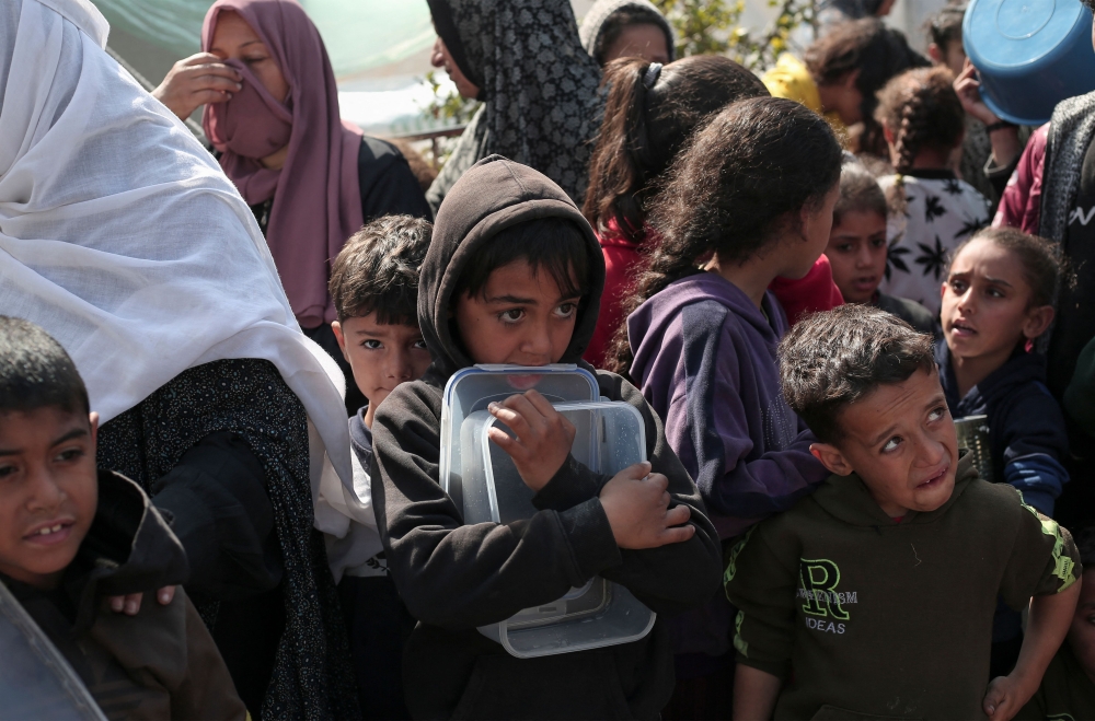 Displaced Palestinians gather for food in Rafah, on the southern Gaza Strip on February 28, 2024. (Photo by AFP)