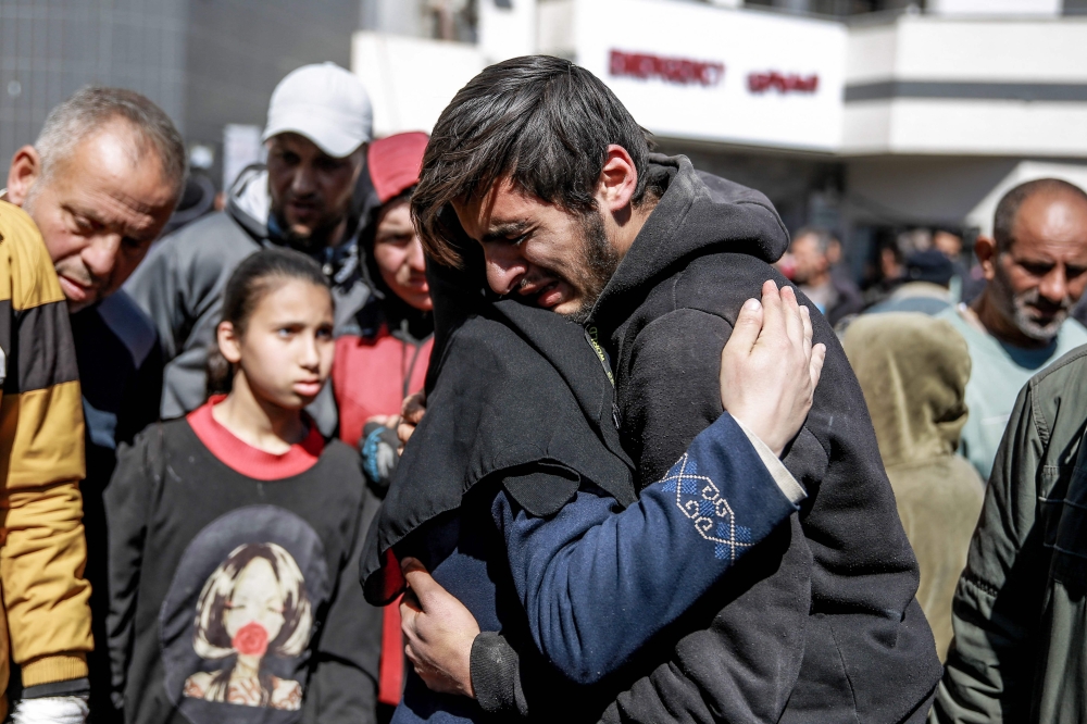 People mourn following an early morning incident when residents rushed toward aid trucks in Gaza City on February 29, 2024. Photo by AFP