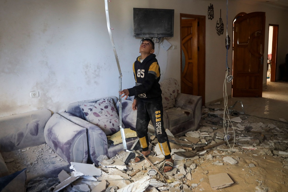 A Palestinian child stands in the living room of a building that was damaged during Israeli bombardment in Rafah, on the southern gaza Strip, on March 2, 2024 (Photo by AFP)