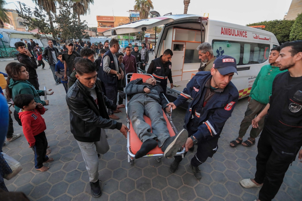 An injured man is stretchered into Al-Aqsa hospital in Deir al-Balah in central Gaza on March 3, 2024, amid the ongoing battles between Israel and the Palestinian Hamas group. (Photo by AFP)
