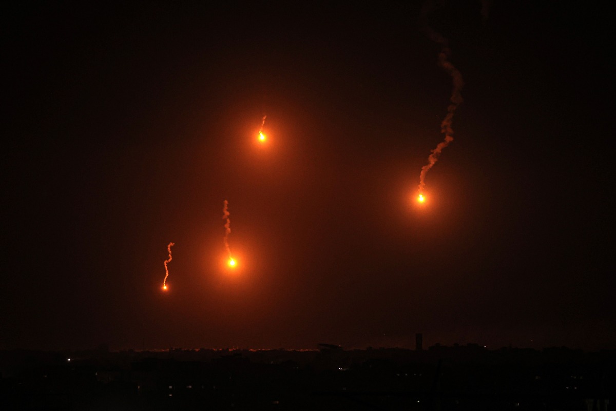 This picture taken from Rafah shows flares lighting the skies over Khan Yunis in the southern gaza Strip on March 4, 2024. (Photo by SAID KHATIB / AFP)
