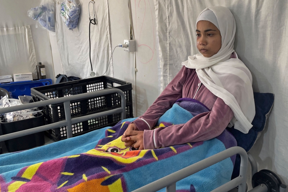 This picture taken on March 6, 2024 shows 15-year-old Palestinian girl Hala Hazem Hamada taking rest inside a hospital in Rafah. The Israeli attack claimed the lives of Hala's six relatives including her parents. (Photo by Said Khatib / AFP)