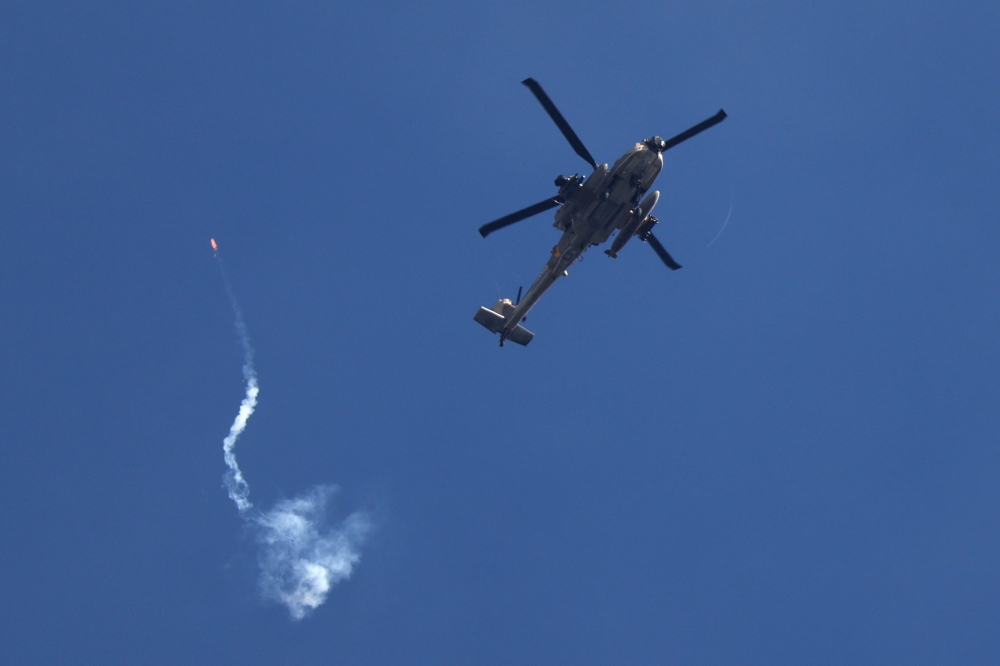 An Israeli military helicopter firing a flare over Gaza on March 7, 2024. (Photo by Jack Guez / AFP)