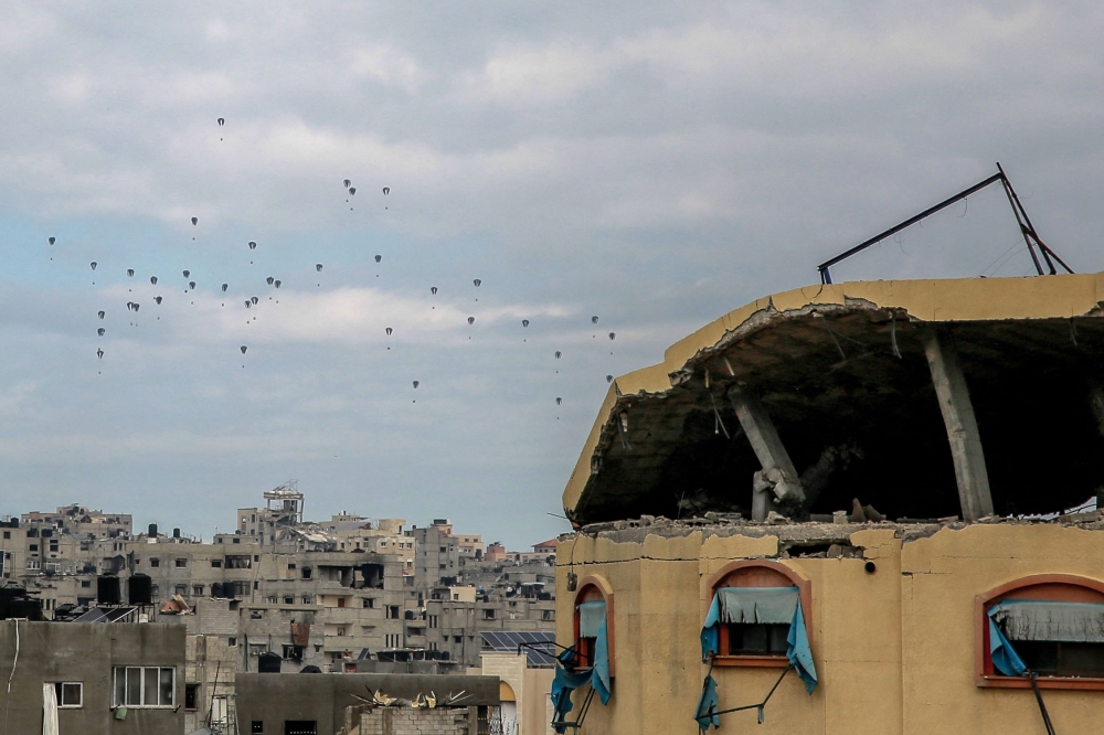 Aid parcels are airdropped over the northern Gaza Strip on March 8, 2024. (Photo by AFP)