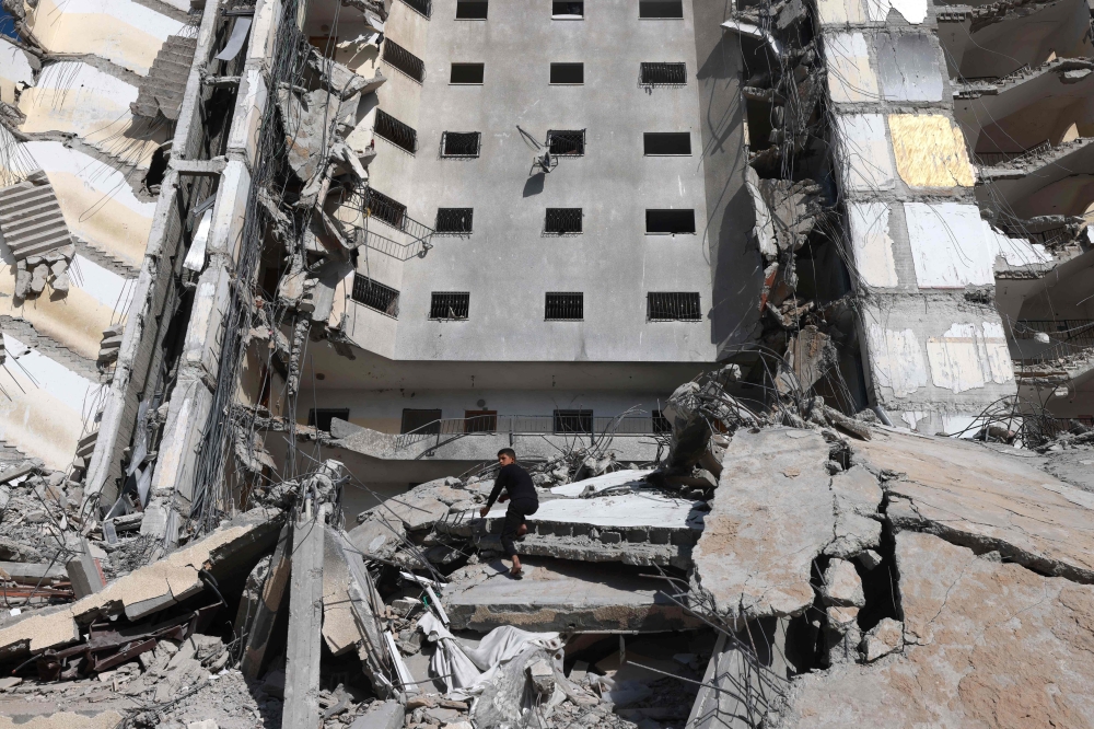 A Palestinian boy inspects the damage to a building hit in an Israeli strike in Rafah, in the southern Gaza Strip on March 10, 2024. (Photo by Mohammed Abed / AFP)
 