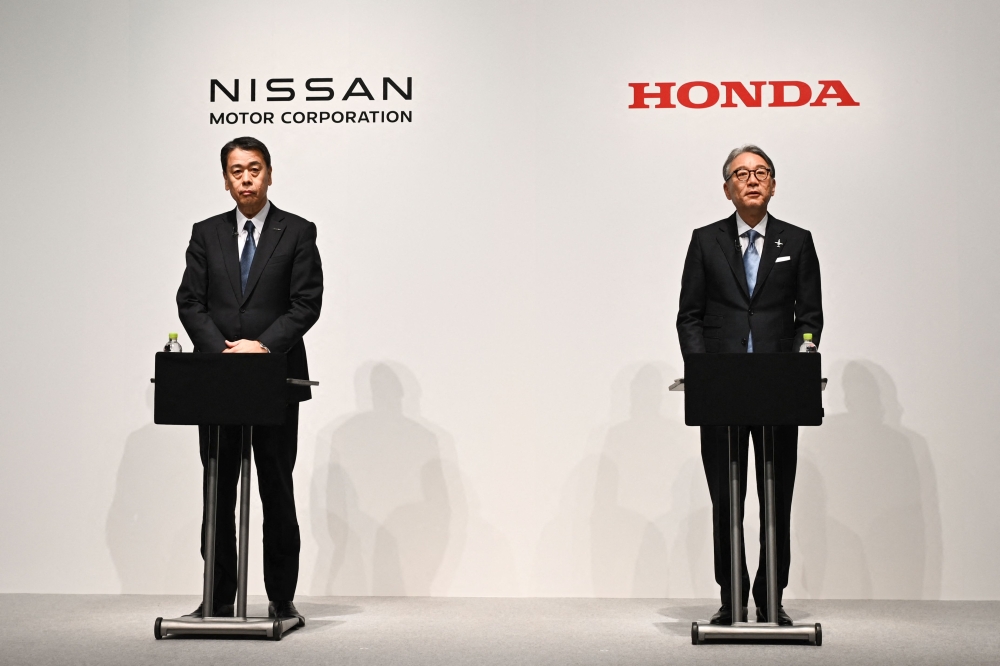 Makoto Uchida, president and CEO of Nissan (L) and Toshihiro Mibe, Honda director, president and representative executive officer attend a joint press conference in Tokyo on March 15, 2025. Photo by Philip FONG / AFP