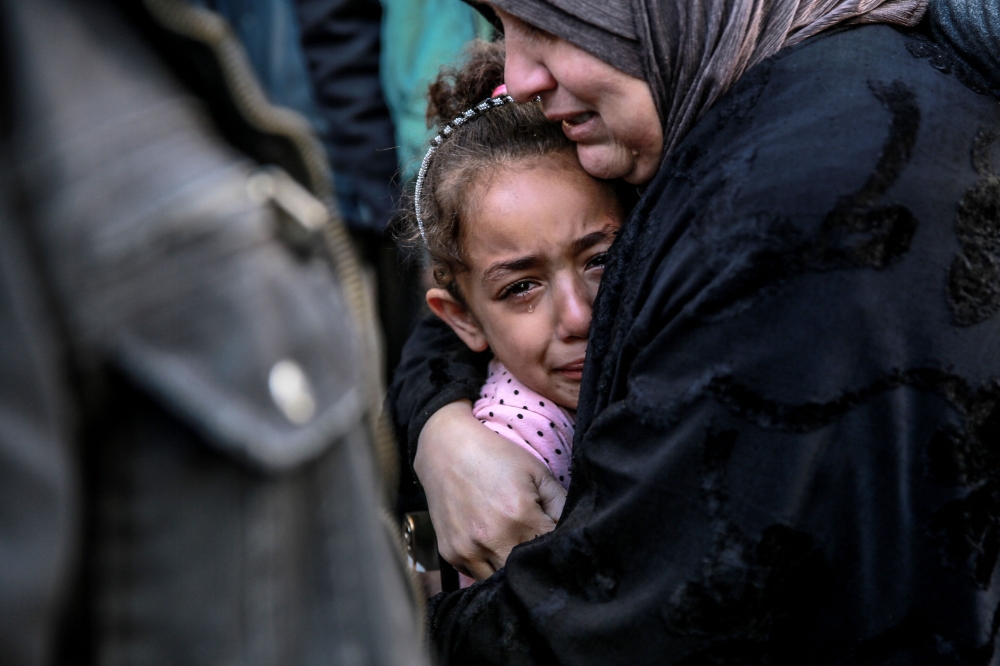 A Palestinian woman holds a child as they mourn their relatives killed in Israeli bombardment in front of the morgue of the Al-Shifa hospital in Gaza City on March 15, 2024, amid the ongoing conflict between Israel and the Palestinian Hamas movement. (Photo by AFP)