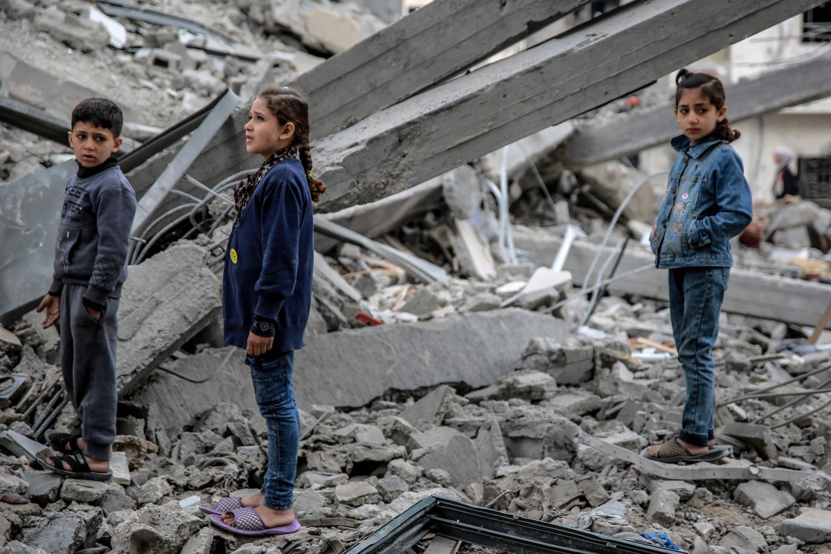 Palestinian children look at the rubble of a building, after it was destroyed in an Israeli strike the night before, in the Rimal neighbourhood of gaza City on March 16, 2024. (Photo by AFP)