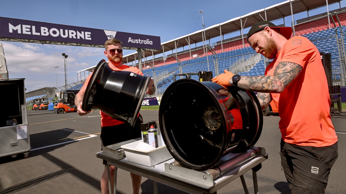 Haas F1 garage technicians John Crawley (R) and Max Cooper (L) prepare tyre rims at the Albert Park circuit as Formula One teams prepare for the upcoming 2024 Formula One Australian Grand Prix, in Melbourne on March 19, 2024. (Photo by William WEST / AFP) 