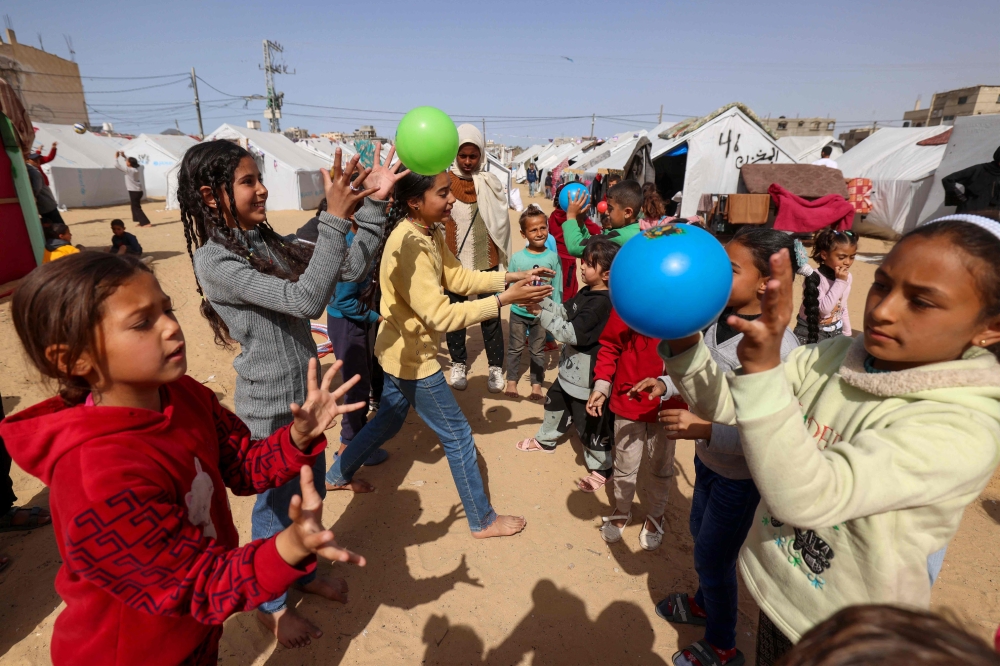 Children take part in organised activities at a camp for displaced Palestinians in Rafah, in the southern Gaza Strip, on March 26, 2024. Photo by MOHAMMED ABED / AFP.