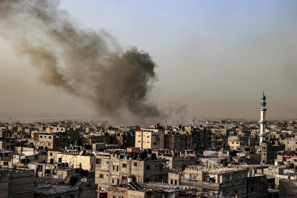 Smoke billows over buildings following Israeli bombardment in Rafah in the southern Gaza Strip on March 27, 2024. (Photo by SAID KHATIB / AFP)
