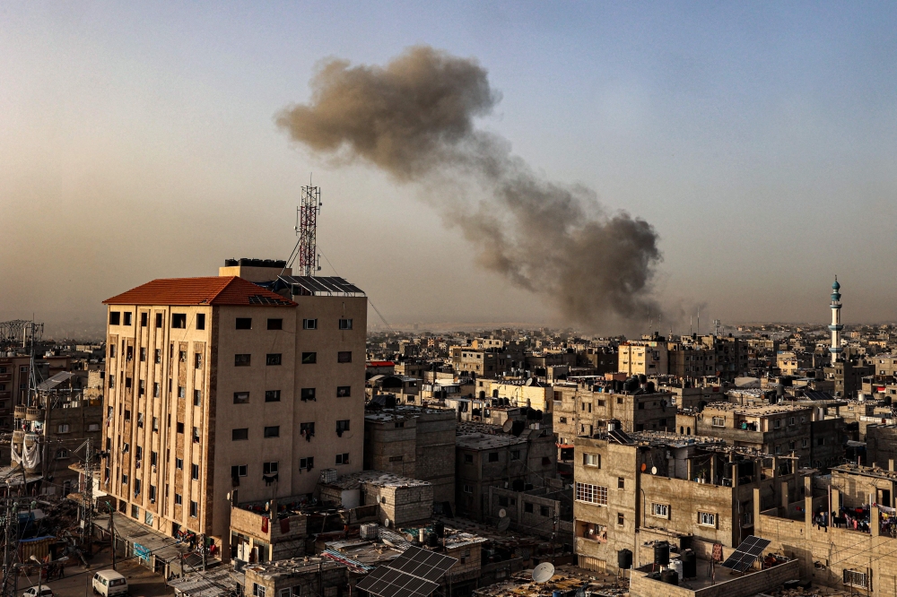 Smoke billows over buildings following Israeli bombardment in Rafah in the southern Gaza Strip on March 27, 2024. (Photo by SAID KHATIB / AFP)
