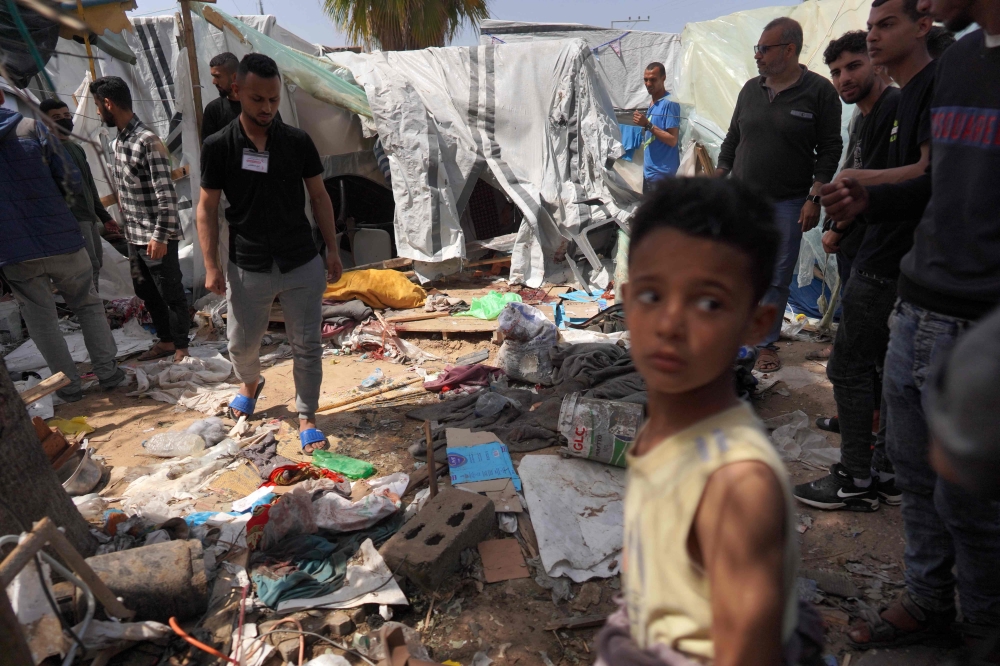 Palestinians check the damage at a makeshift camp for displaced people in front of the Al-Aqsa Martyrs Hospital in Deir al-Balah in the central Gaza Strip, after it was hit by Israel bombardment on March 31, 2024. (Photo by AFP)
 