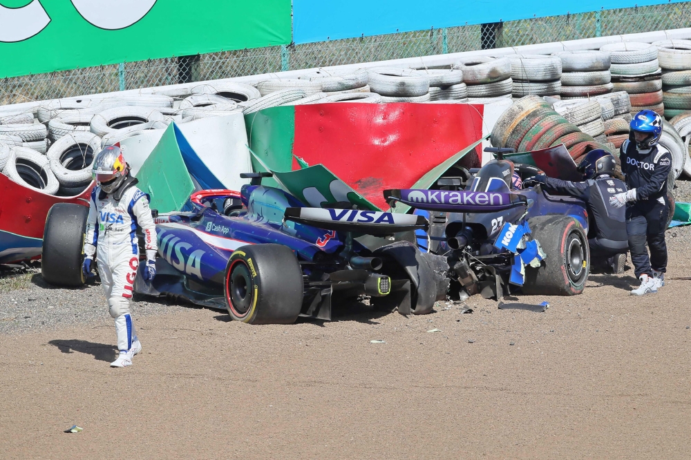 RB's Australian driver Daniel Ricciardo (L) gets out of his car after crashing out with Williams' Thai driver Alexander Albon (R-in car) during the Formula One Japanese Grand Prix race at the Suzuka circuit in Suzuka, Mie prefecture on April 7, 2024. (Photo by JIJI PRESS / AFP) / Japan OUT