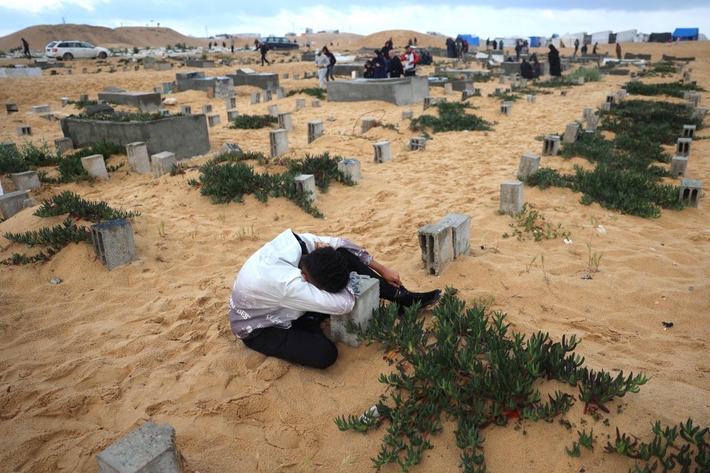 A man visits the grave of a loved one at the start of the Eid Al Fitr festival, marking the end of the Muslim holy month of Ramadan, at a cemetery in Rafah in the southern Gaza Strip, on April 10, 2024. (Photo by AFP)

