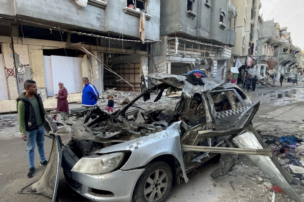 Onlookers check the car in which three sons of Ismail Haniyeh were reportedly killed in an Israeli air strike in al-Shati camp, west of Gaza City on April 10, 2024. (Photo by AFP)