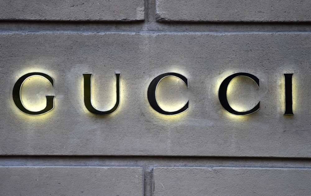 This picture taken on December 19, 2017 shows a logo outside the fashion house and luxury goods Gucci shop on the Avenue Montaigne in Paris, ahead of Christmas. Photo by STEPHANE DE SAKUTIN / AFP