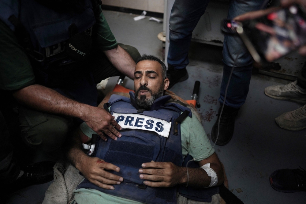 Photojournalist Sami Shahadeh arrives for treatment at the Al-Aqsa Martyrs Hospital in Deir el-Balah on April 12, 2024, after he was wounded by Israeli bombardment. (Photo by AFP)