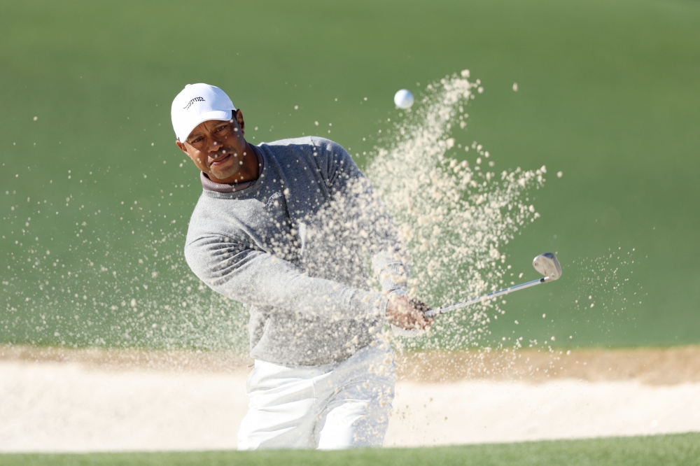  Tiger Woods of the United States plays a shot from a bunker on the 18th hole during the continuation of the first round of the 2024 Masters Tournament at Augusta National Golf Club on April 12, 2024 in Augusta, Georgia. (Photo by Warren Little / GETTY IMAGES NORTH AMERICA / Getty Images via AFP)
