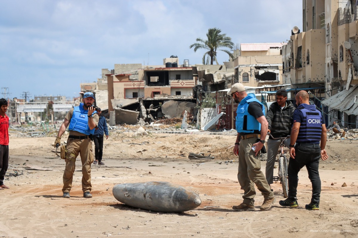 A UN team inspects an unexploded 1,000-pound bomb lying on a main road in Khan Younis. Pic: UNOCHA/Themba Linden 