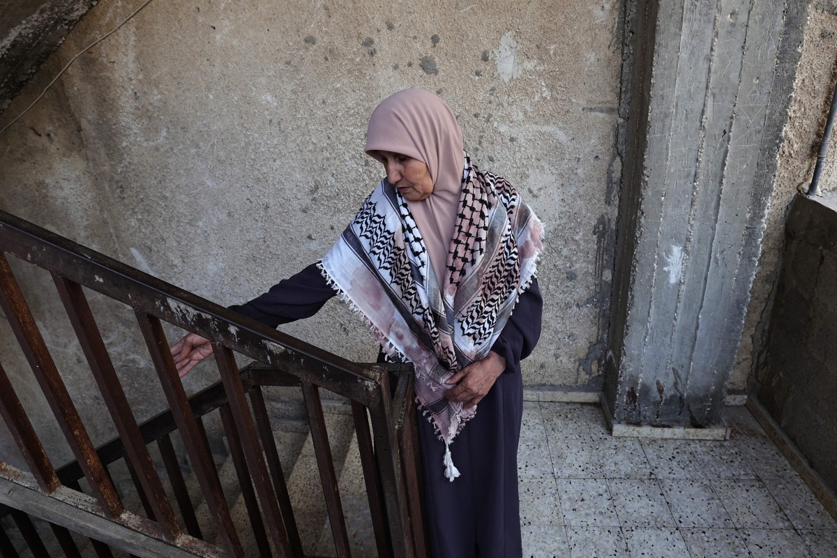 Amina Ghannam looks on as she wears a Keffiyeh stained in the blood of two of her sons who were killed in a raid by Israeli forces in the Nur Shams camp for Palestinian refugees in the occupied west bank on April 21, 2024.(Photo by Zain JAAFAR / AFP)