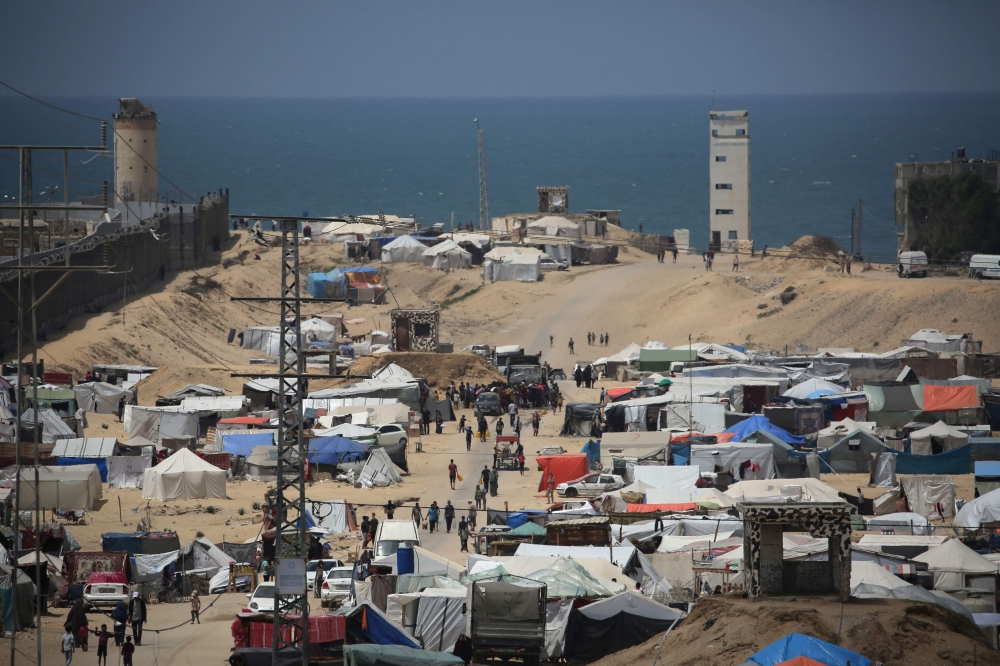 People walk in a camp for displaced people in Rafah in the southern Gaza Strip by the border with Egypt on April 28, 2024. (Photo by AFP)