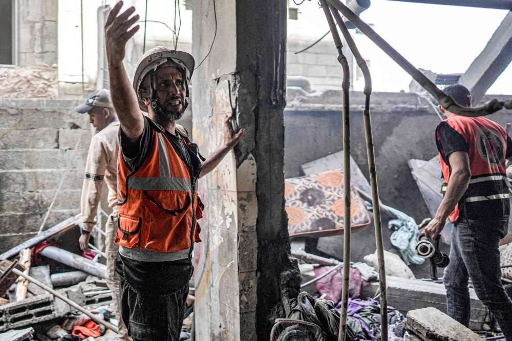 First responders search a building following Israeli bombardment in Nuseirat in the central Gaza Strip on April 29, 2024. (Photo by AFP)
