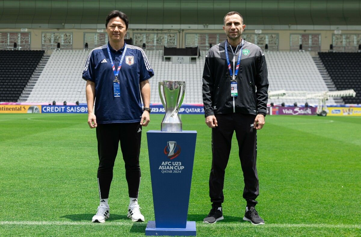 Japan coach Go Oiwa (left) and Uzbekistan coach Timur Kapadze pose with the AFC U23 Cup trophy on the eve of the final in Doha. 