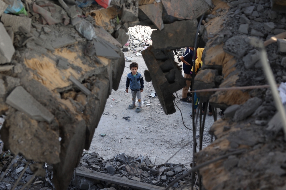 A Palestinian child stands in front of a building destroyed by Israeli bombing in Rafah in the southern Gaza Strip on May 3, 2024. (Photo by AFP)