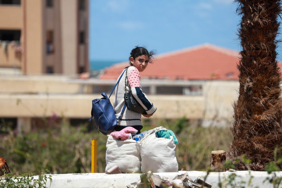 Displaced Palestinians who left with their belongings from rafah in the southern Gaza Strip following an evacuation order by the Israeli army, unload their belongings to set up shelter in Khan Yunis on May 6, 2024. (Photo by AFP)
