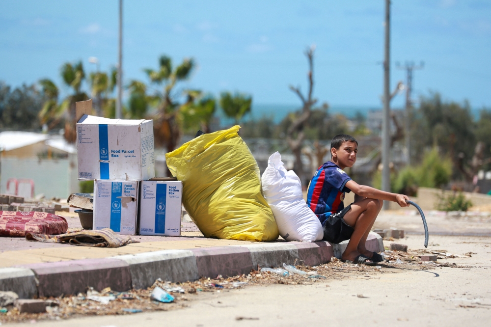 Displaced Palestinians who left with their belongings from Rafah in the southern Gaza Strip following an evacuation order by the Israeli army, unload their belongings to set up shelter in Khan Yunis on May 6, 2024. Photo by AFP.