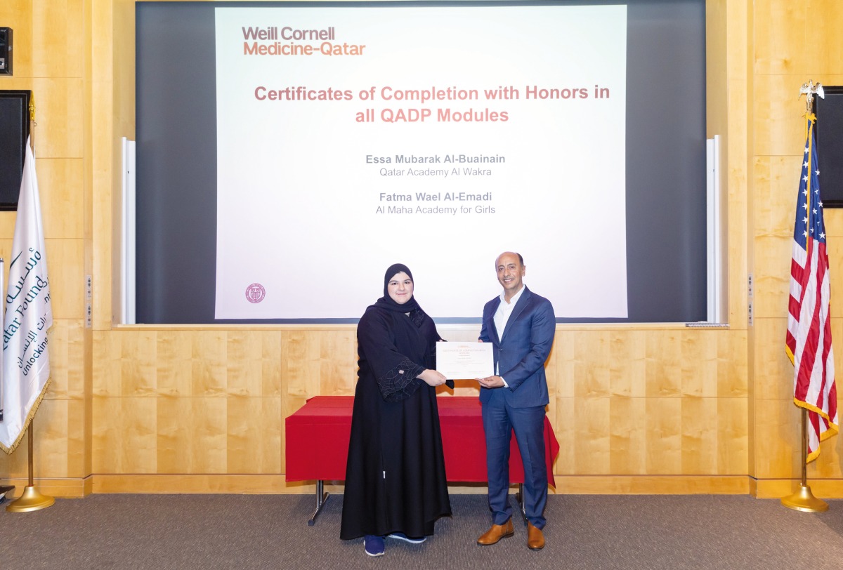 Fatma Wael Al Emadi, from Al Maha Academy for Girls, receiving her honours certificate from Dr. Rachid Bendriss (right).