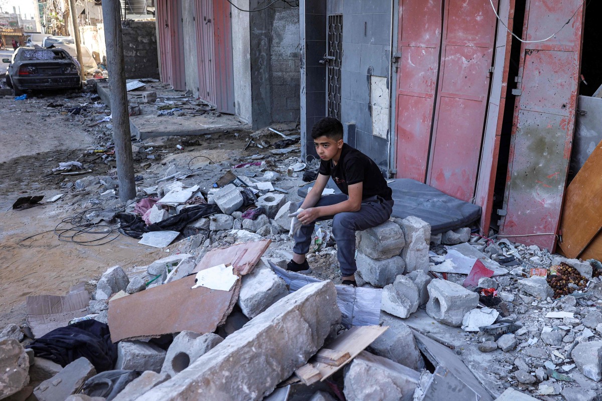 A boy sits amidst rubble at the site of a building that was hit by Israeli bombardment in Rafah in the southern gaza Strip on May 8, 2024. (Photo by AFP)