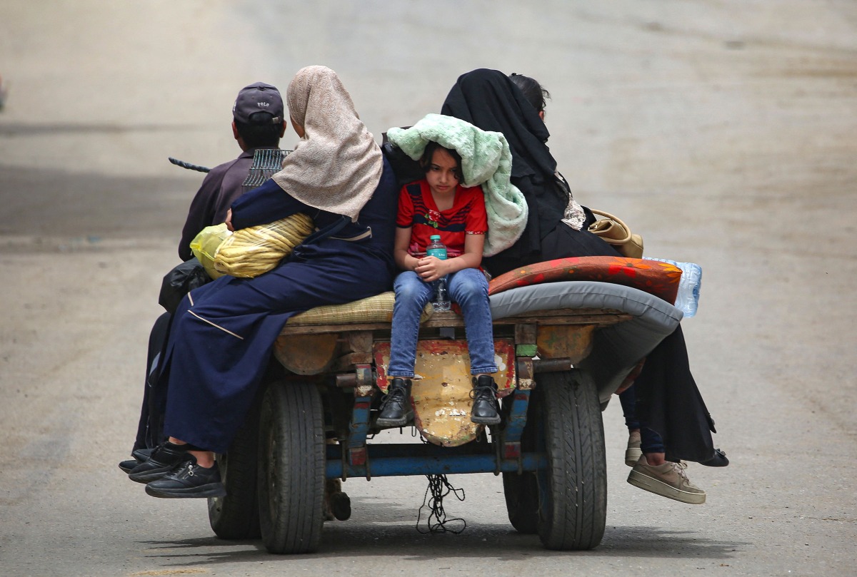 Palestinians sit on an animal pulled cart as they move to safer areas in rafah, in the southern Gaza Strip. (Photo by AFP)
