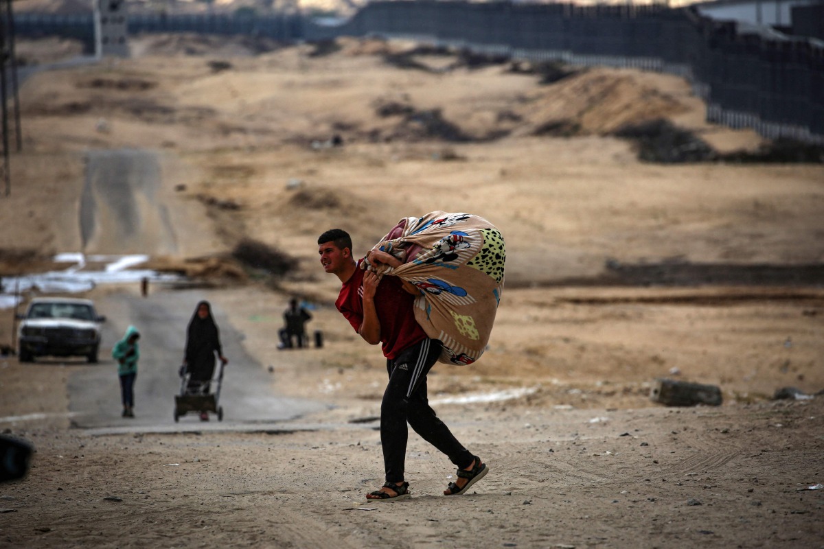 Palestinians carry their belongings as they prepare to flee rafah in the southern Gaza Strip on May 13, 2024. (Photo by AFP)