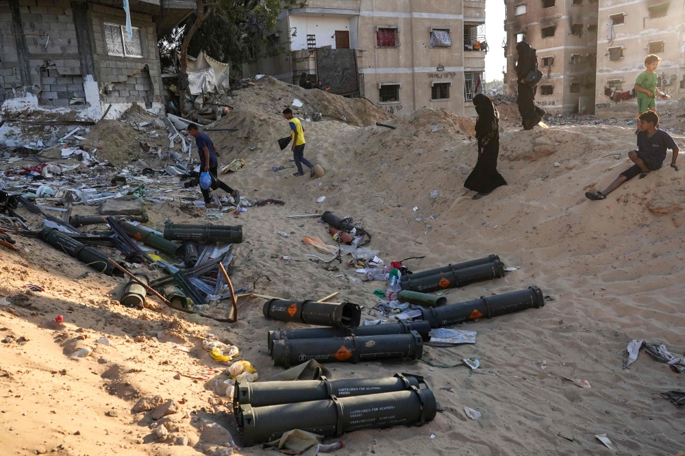 Palestinian children gather empty ammunition containers in Khan Yunis in the southern Gaza Strip on May 16, 2024. (Photo by AFP)