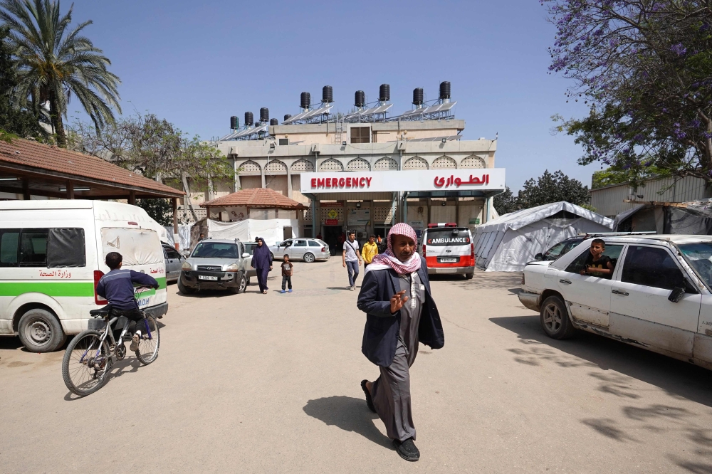 Palestinians walk outside the European hospital in Khan Yunis in the southern Gaza Strip on May 17, 2024. (Photo by AFP)