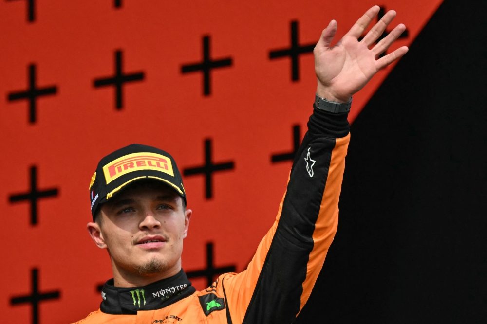 Second-placed McLaren's British driver Lando Norris waves on the podium of the Emilia Romagna Formula One Grand Prix at the Autodromo Enzo e Dino Ferrari race track in Imola on May 18, 2024. (Photo by ANDREJ ISAKOVIC / AFP)