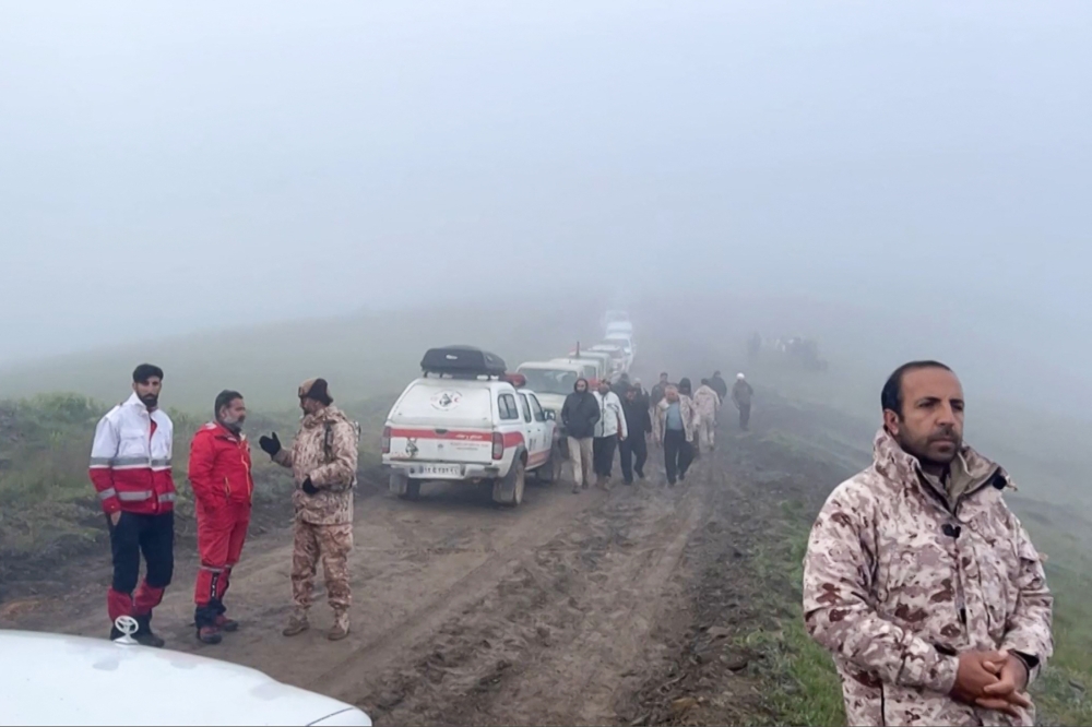 This frame grab from video released by the Iranian Red Crescent on May 20, 2024, shows members of a search and rescue team in Iran's East Azerbaijan province. (Photo by Handout / Iranian Red Crescent / AFP)