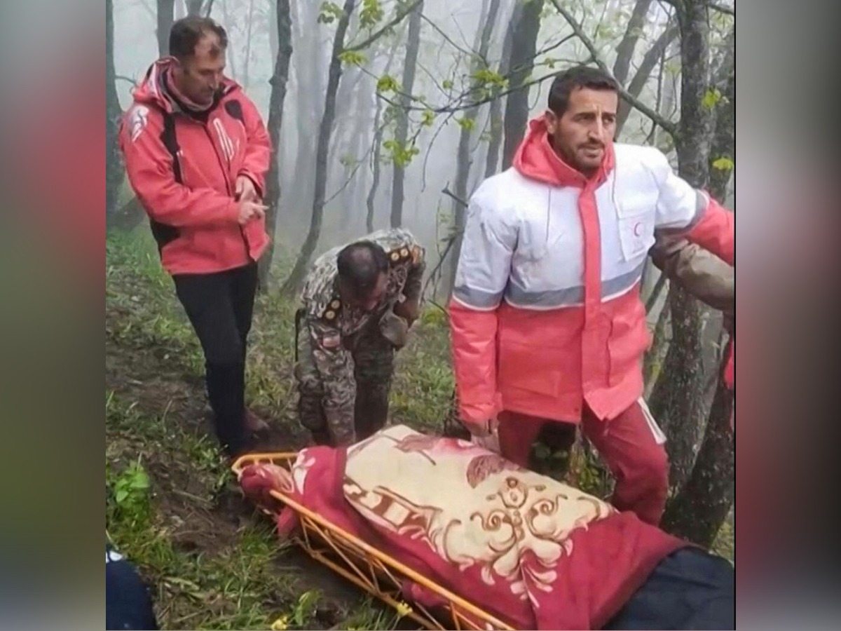 This grab taken from handout video footage released by the Iranian Red Cescent on May 20, 2024 shows rescuers recovering bodies at the site of President Ebrahim Raisi's helicopter crash in a fog-shrouded mountainous area of northwest Iran. (Photo by Iranian Red Crescent / AFP)