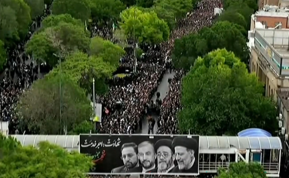 This grab taken from handout video footage released by Iran Press on May 21, 2024 shows people gathering to mourn during a funeral procession in the northwestern city of Tabriz, the capital of East Azerbaijan province. (Photo by Iran Press / AFP) 