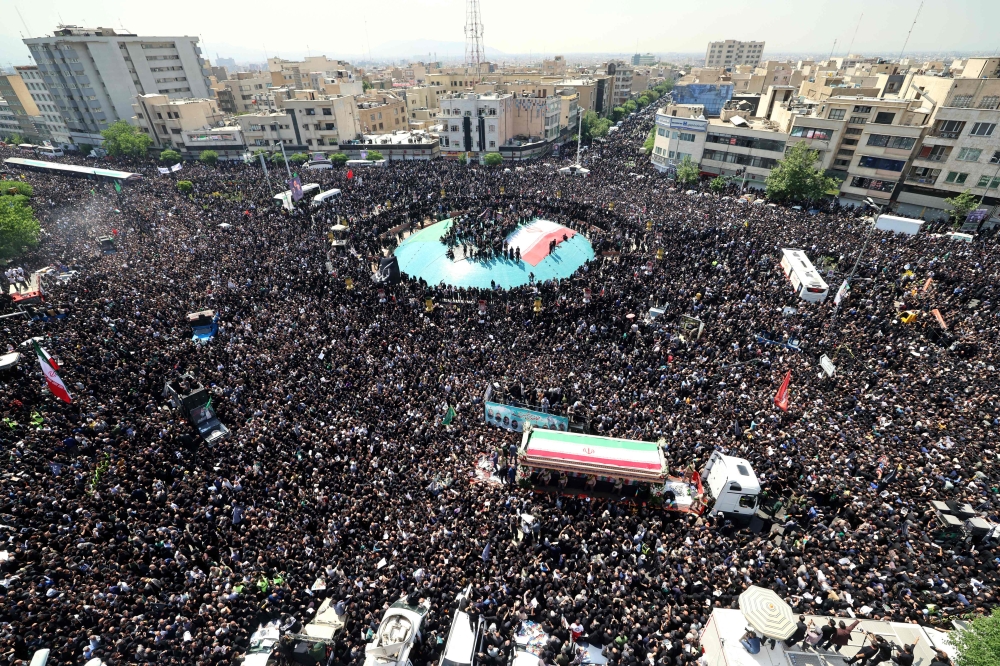 Mourners attend the funeral of Iran's President Ebrahim Raisi, in Tehran on May 22, 2024. (Photo by ATTA KENARE / AFP)